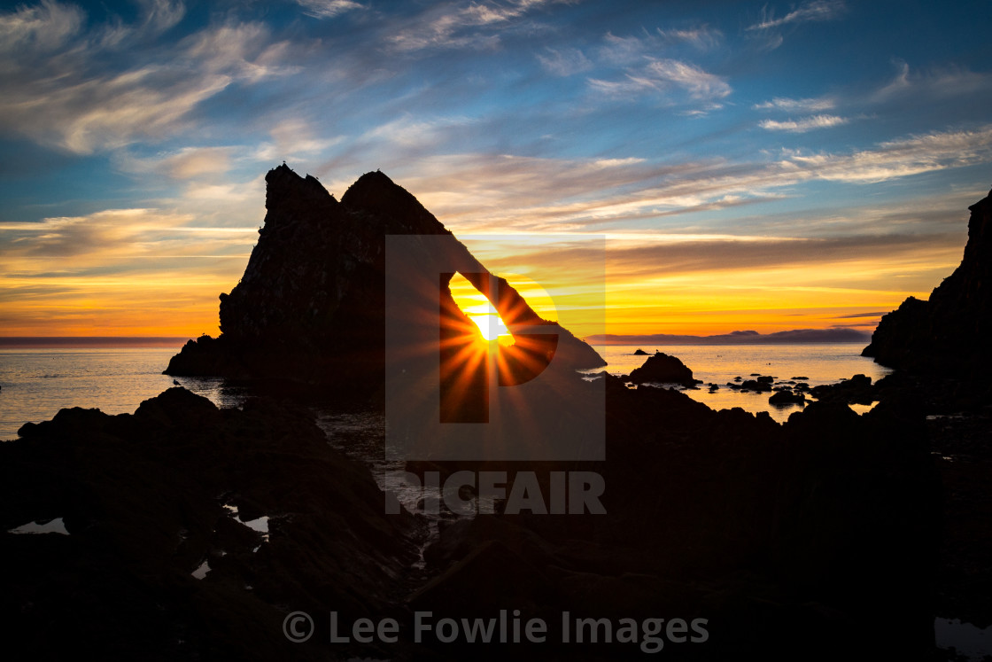 "Sunrise through the Arch, Bow Fiddle Rock" stock image