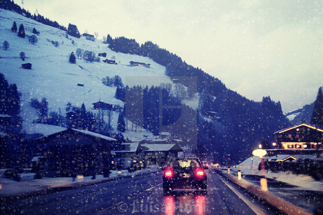 "Car traffic on a mountain route during a snow storm on the Austrian Alps at dusk" stock image