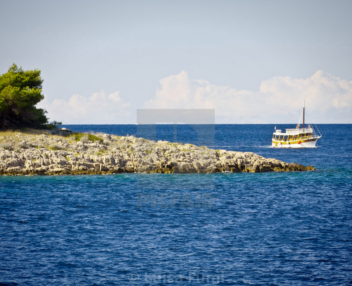 "Croatia: Blue clear sea water, boat and island" stock image