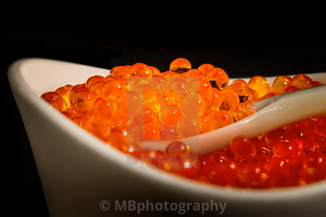 "Salmon caviar in a bowl on a mother of pearl spoon" stock image