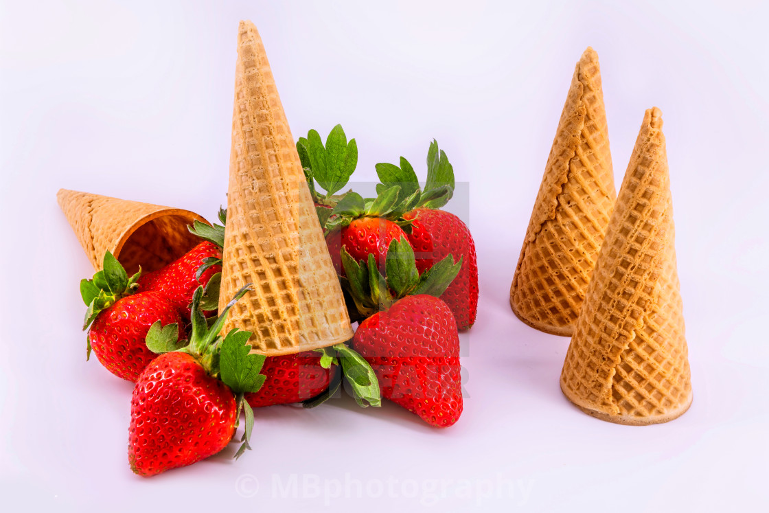 "Fresh strawberries and waffle cones on white background" stock image