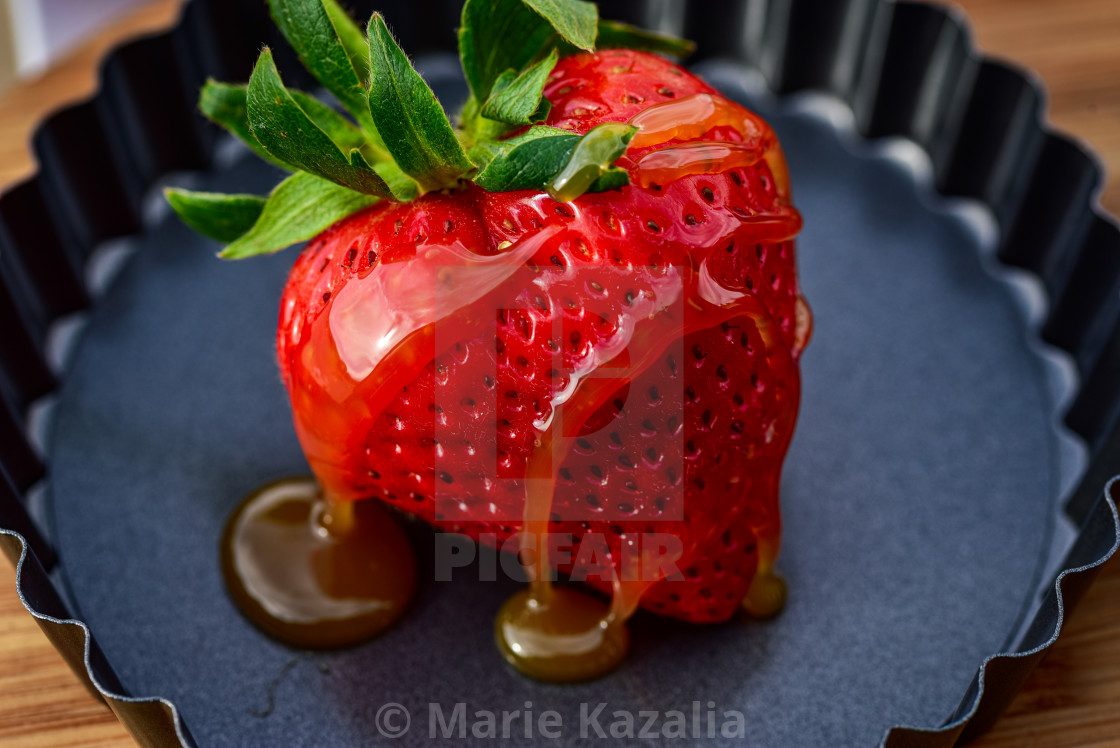 "whole ripe strawberry drizzled with honey caramel sauce" by Marie Kazalia - $15.44 "whole ripe strawberry drizzled with honey caramel sauce" stock image