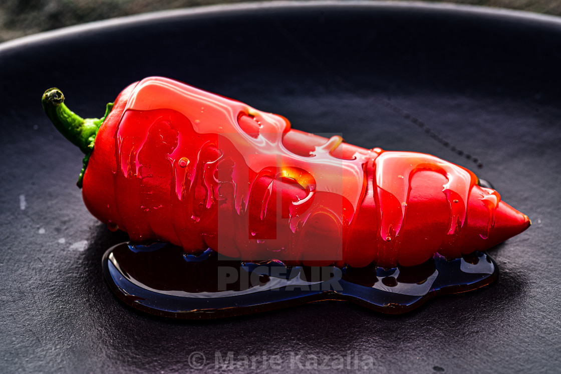 "closeup of red chili pepper drizzled with honey" by Marie Kazalia - $15.44 "closeup of red chili pepper drizzled with honey" stock image