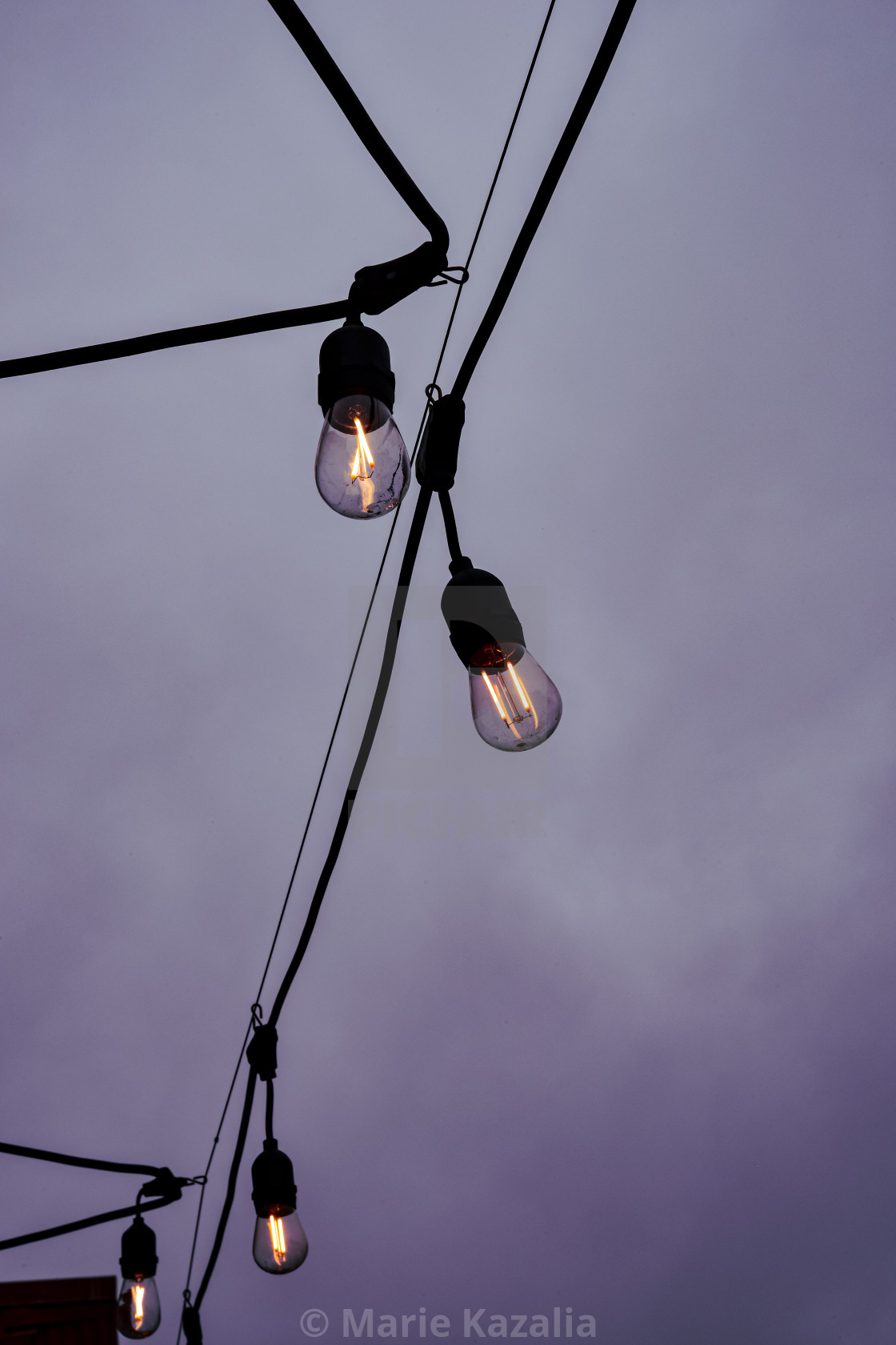 "Lit Edison lightbulbs hanging on wire against dark overcast sky" by Marie Kazalia - $15.16 "Lit Edison lightbulbs hanging on wire against dark overcast sky" stock image