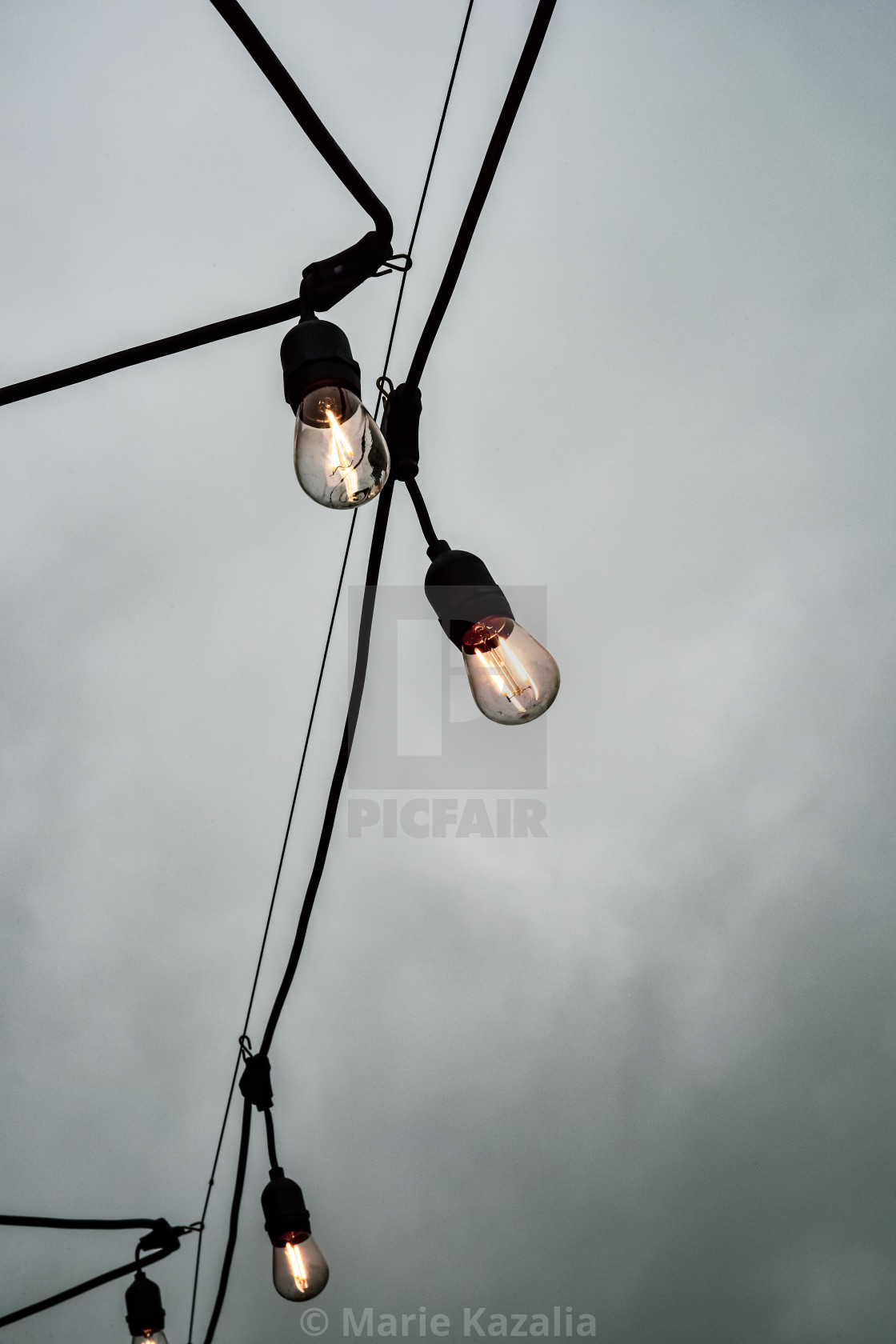 "Illuminated Edison lightbulbs on wire against overcast sky" by Marie Kazalia - $15.16 "Illuminated Edison lightbulbs on wire against overcast sky" stock image