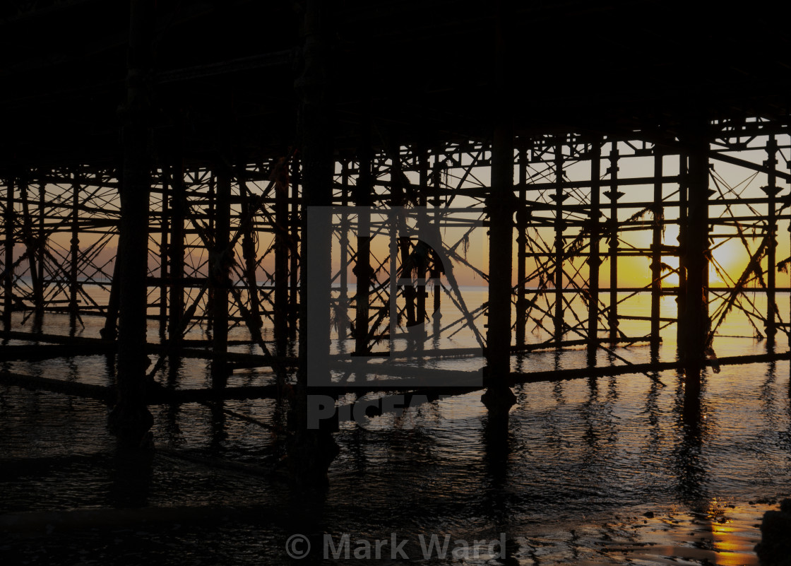 "Under Hastings Pier at Sunset." stock image