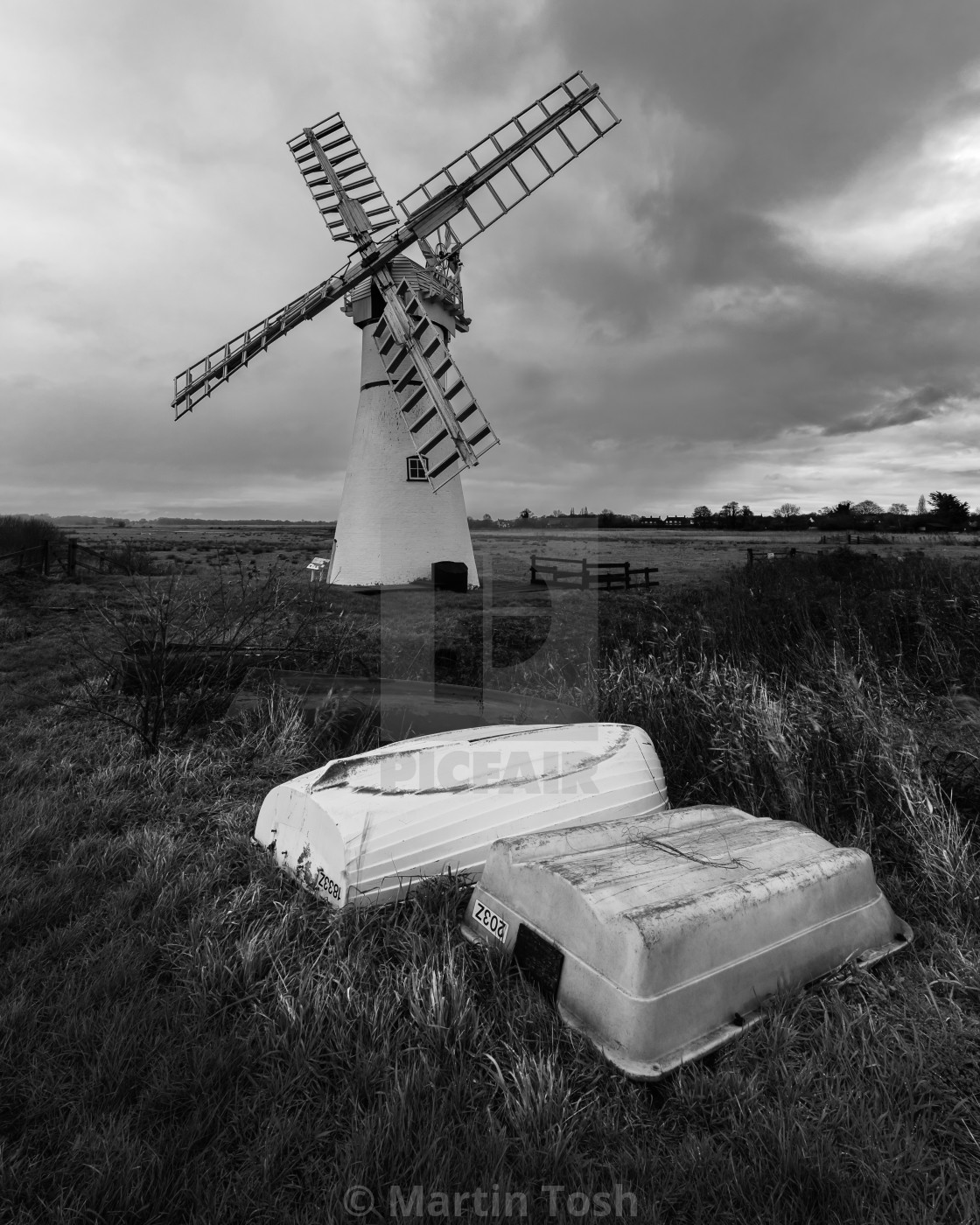 "Norfolk winpump mono with upturned rowing boats fg." stock image