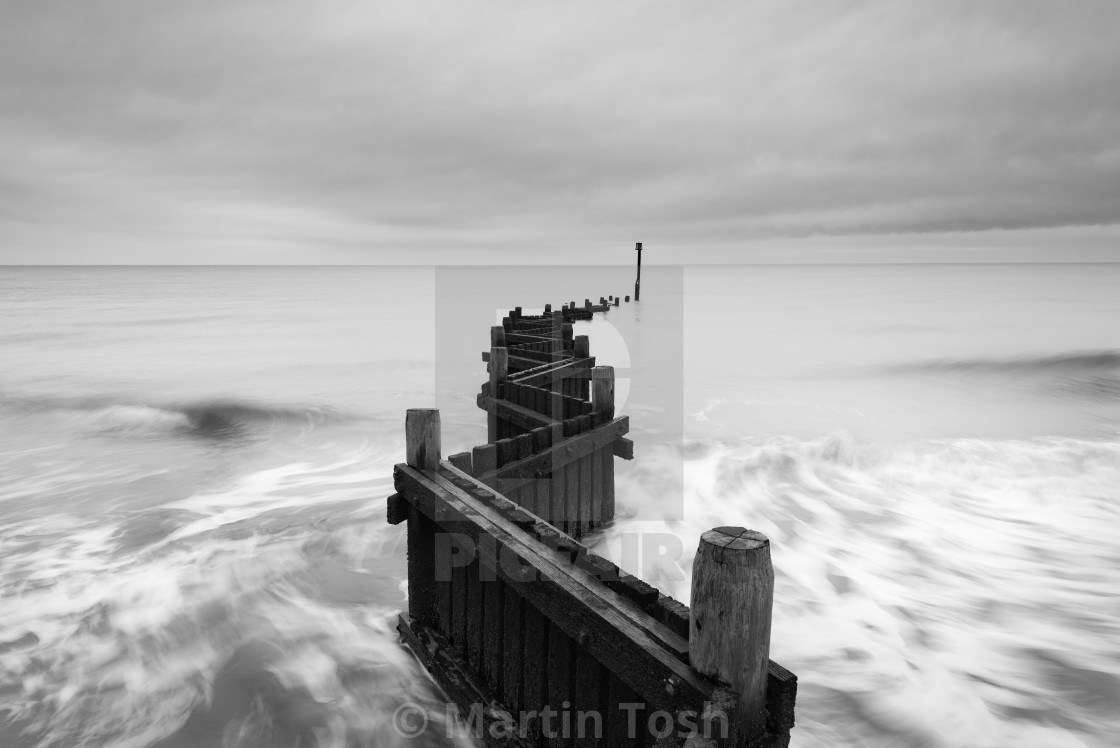 "Old wooden sea defences mono iv slow shutter water movement zig zag view." stock image