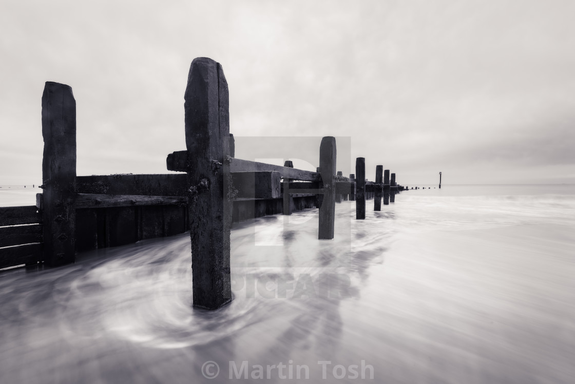 "Old wooden sea defences mono iii slow shutter water movement side view." stock image