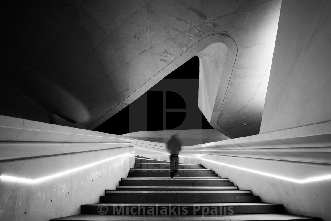 "Unrecognized person walking at the stairs leading to a bright open space. Eleftheria square Nicosia Cyprus" stock image