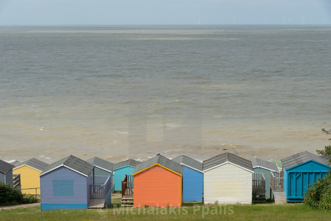 "Colorful holiday beach huts homes facing the calm blue sea." stock image