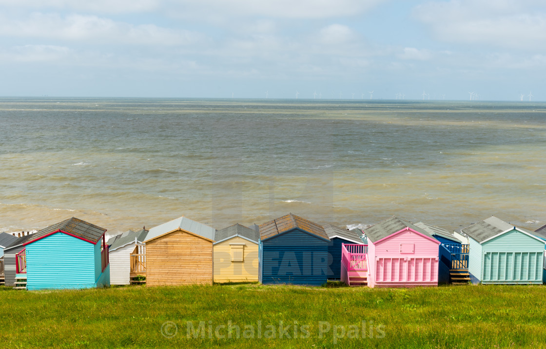 "Colorful holiday beach huts homes facing the calm blue sea." stock image