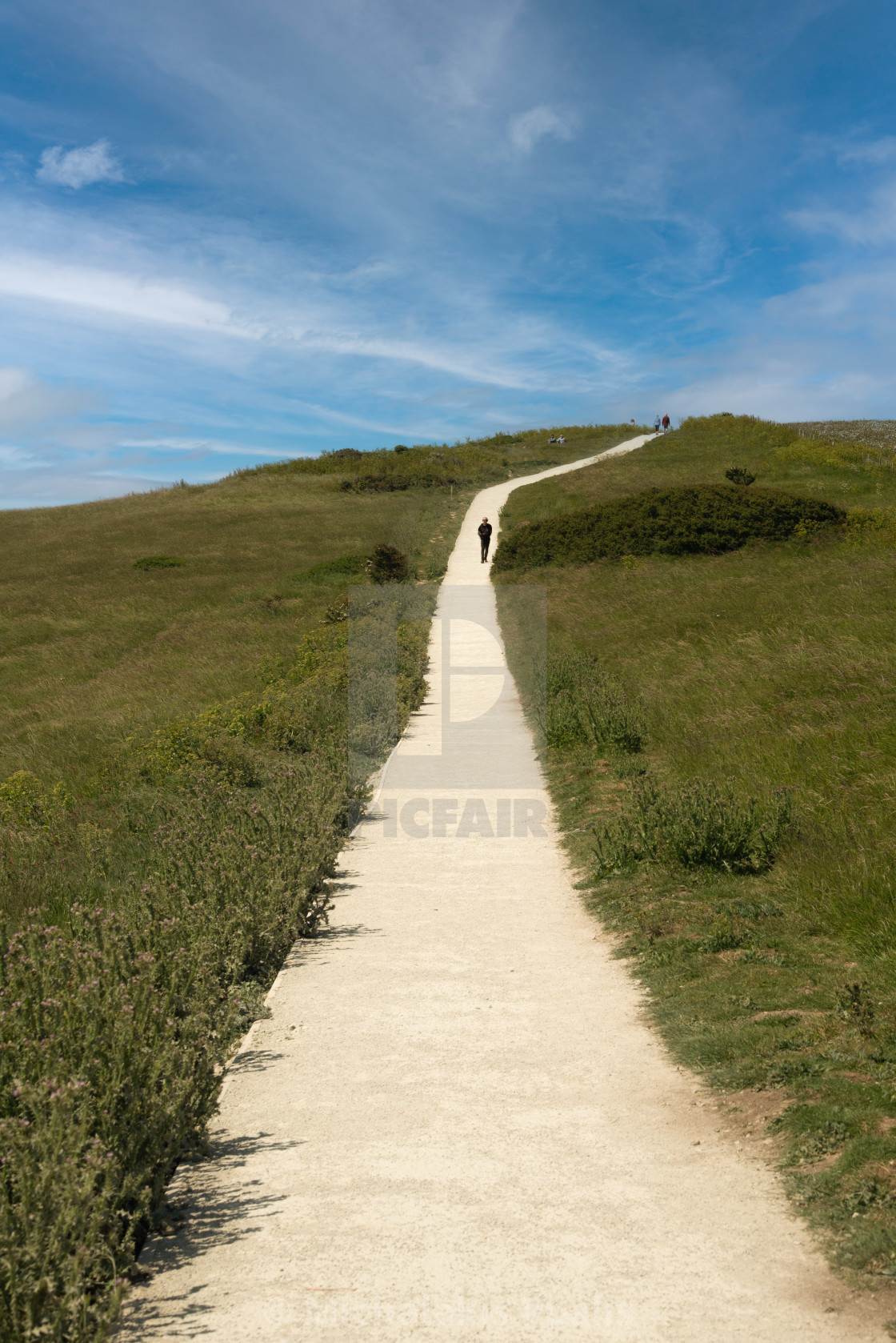 "Unrecognized people trekking on a footpath on white cliffs of Dover national reserve park. United Kingdom." stock image