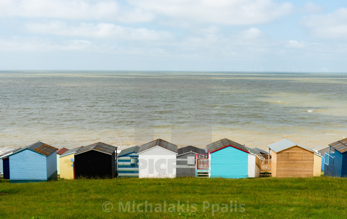 "Colorful holiday beach huts homes facing the calm blue sea." stock image