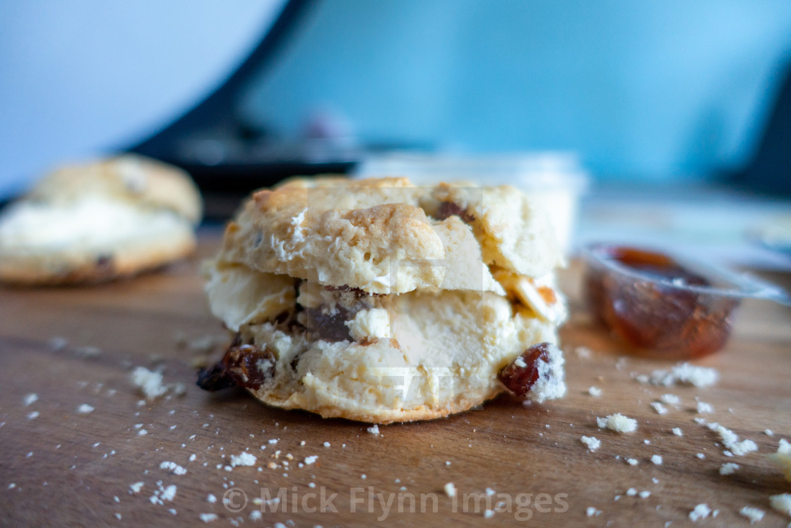 "Close up of scones with clotted cream, jam and crumbs." stock image