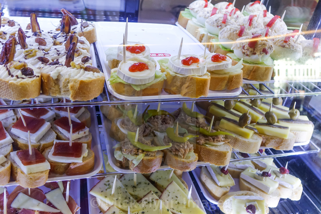 "Tapas on display in glass cases on Spanish bar" stock image