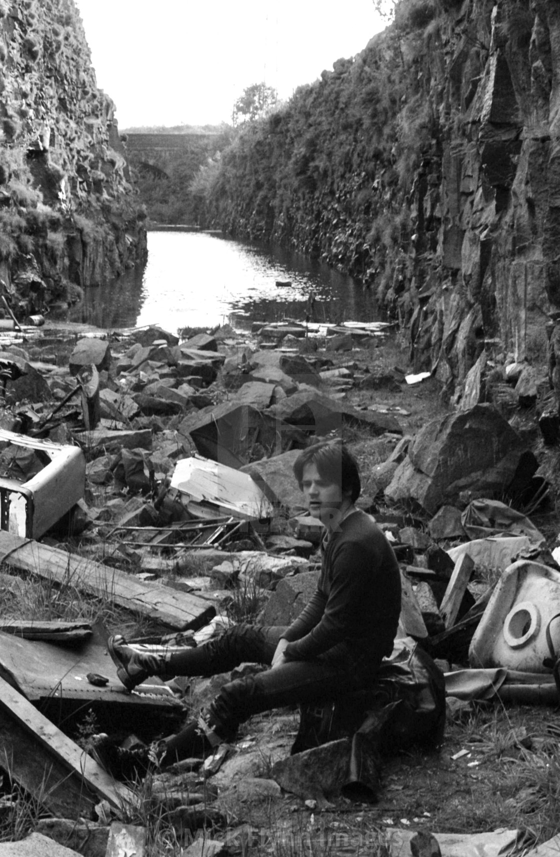 "Young man sitting on rubble in the flooded Strines cutting on the former..." stock image