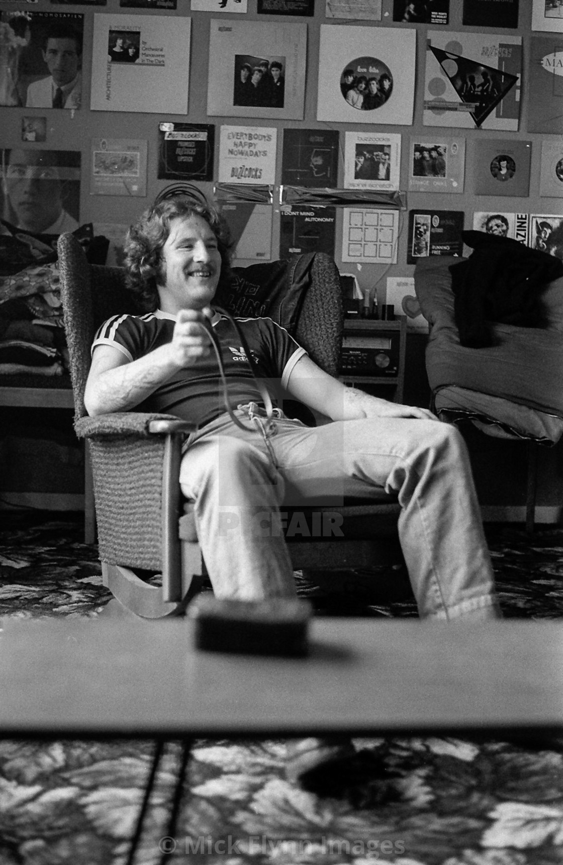 "Young man in a flat with record covers on the wall and AKG headphones 1982" stock image