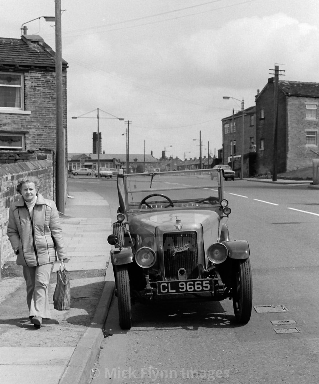 "Wyke, Bradford, woman walking past Jowett motor car circa 1982" stock image