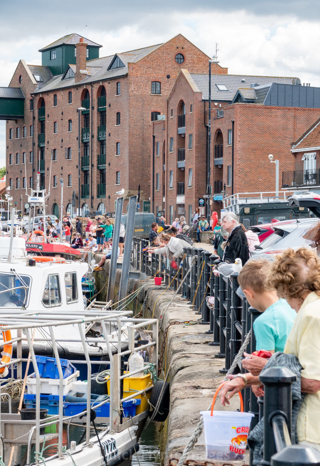 "Families using drop nets to catch crabs over Wells-next-the-sea harbour wall..." stock image