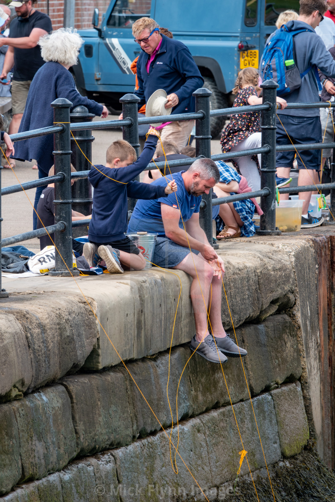 "Families using drop nets to catch crabs over Wells-next-the-sea harbour wall..." stock image