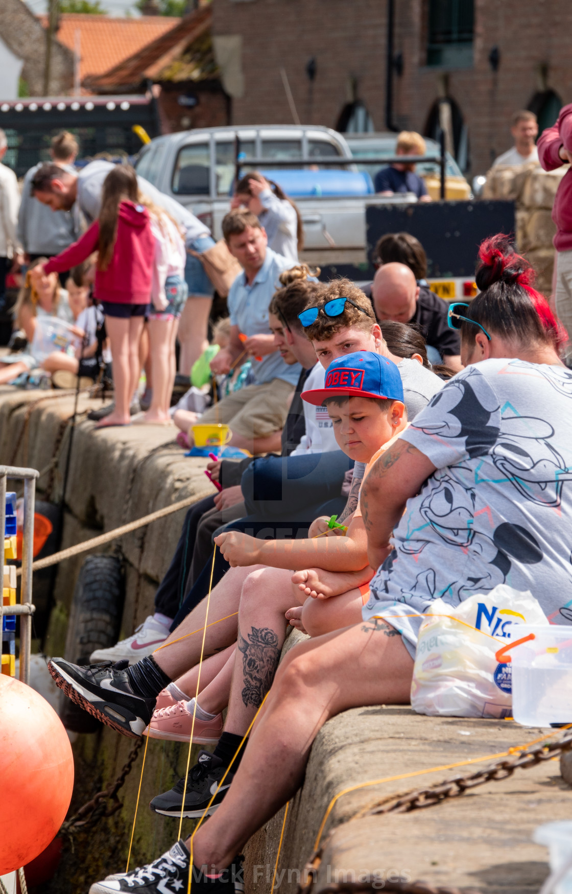 "Families using drop nets to catch crabs over Wells-next-the-sea harbour wall..." stock image