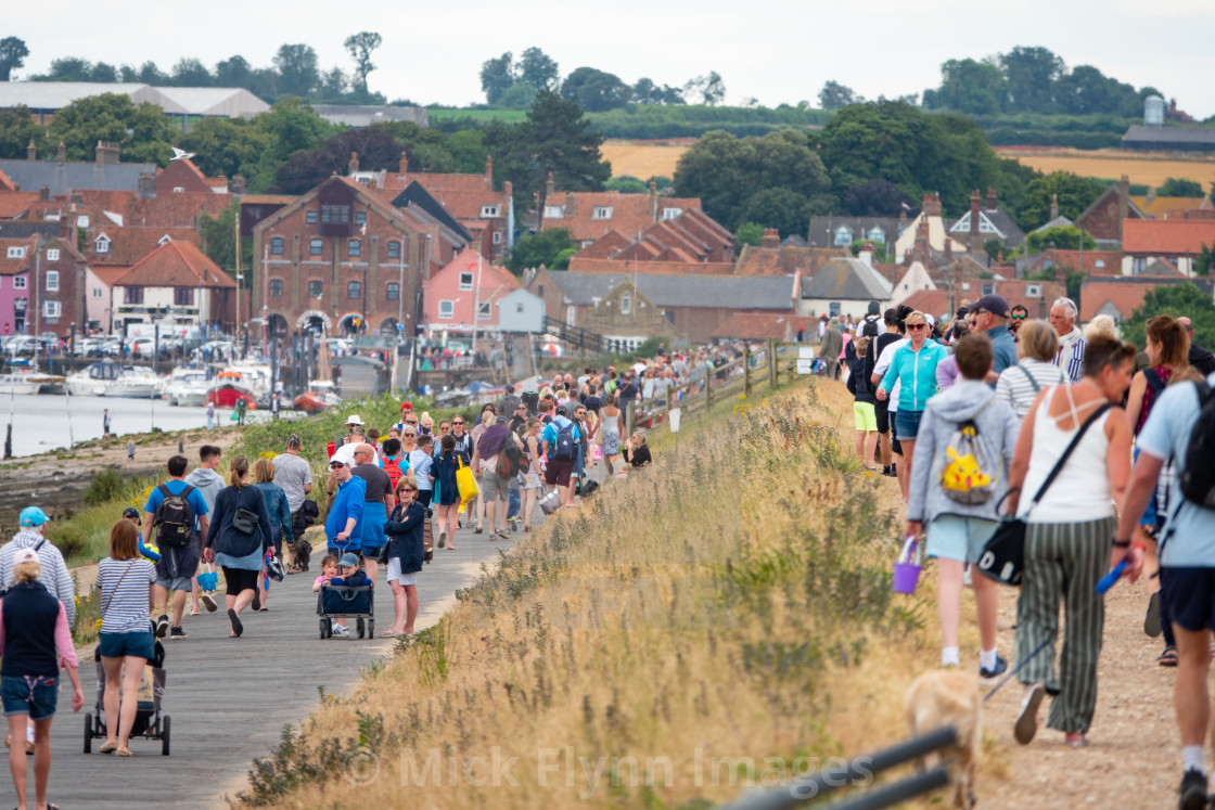 "Staycationers and day trippers walk along a crowded Beach road in..." stock image