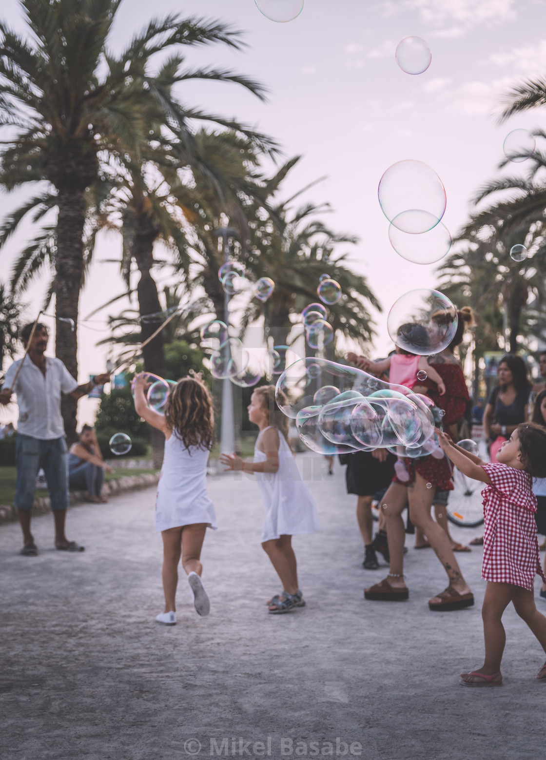 "Children trying to catch soap bubbles in Sitges" stock image