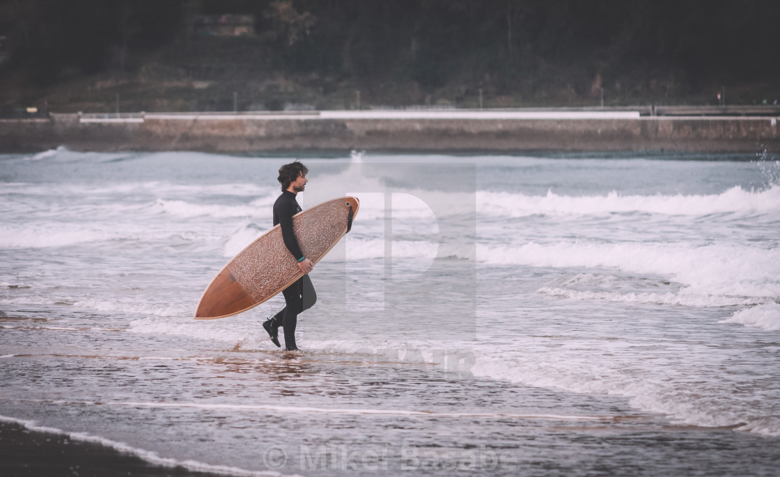 "A surfer boy getting ready to surf" stock image