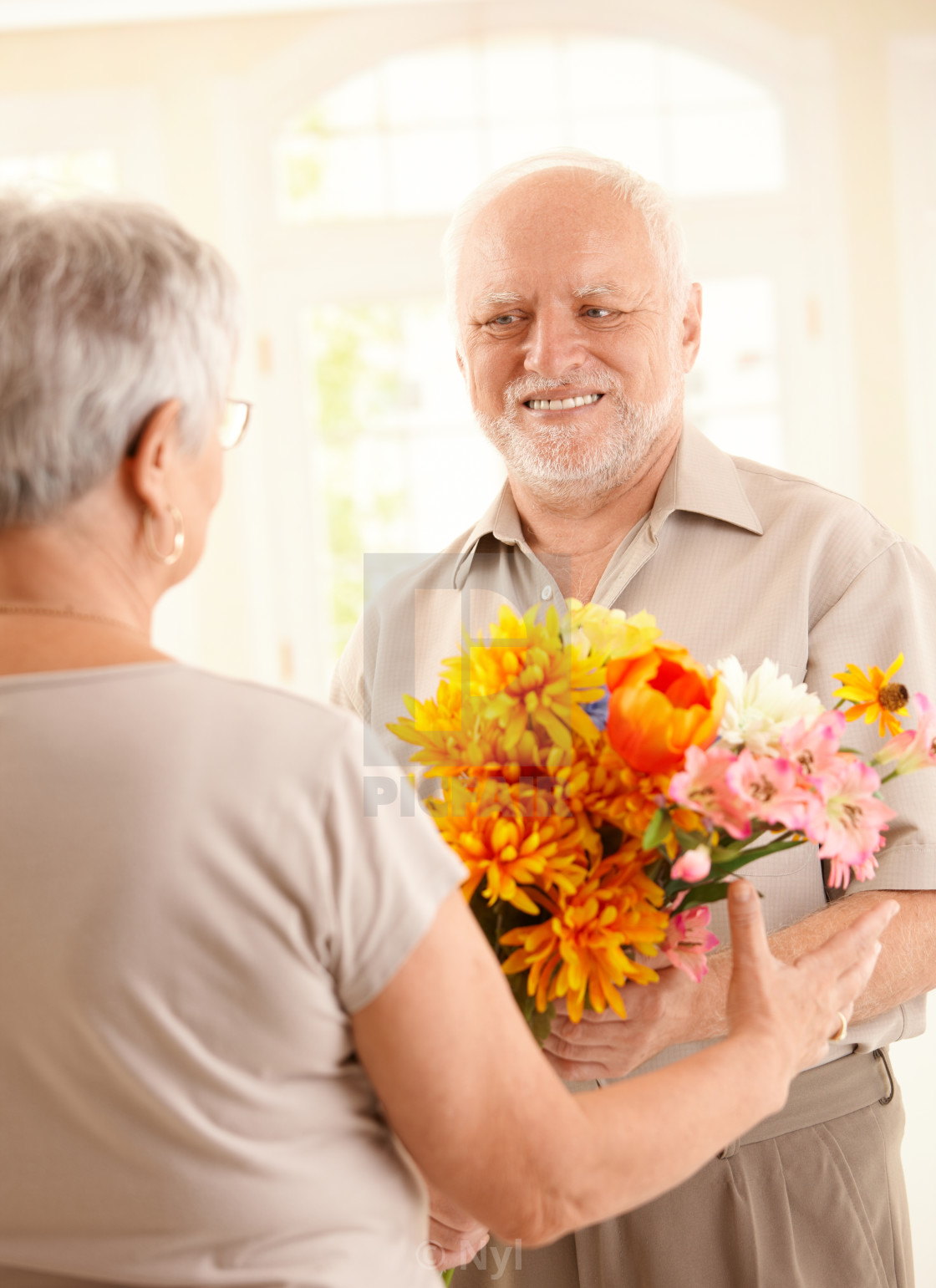 "Smiling senior man bringing flowers" stock image