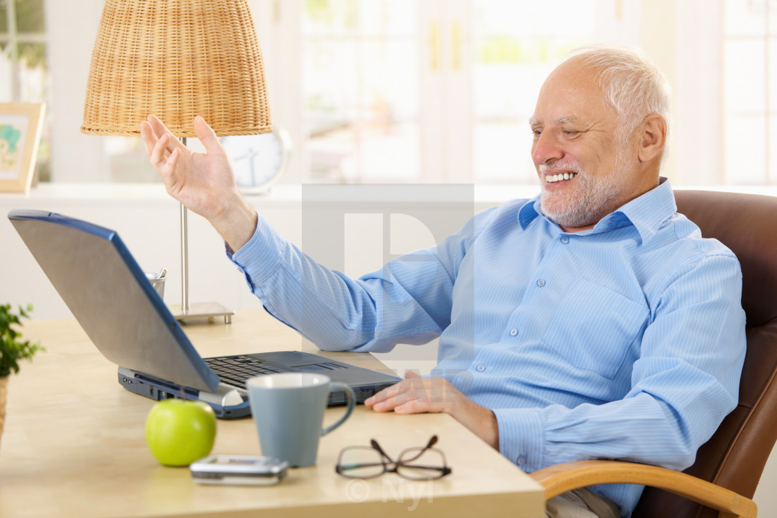 "Laughing old man using laptop" stock image
