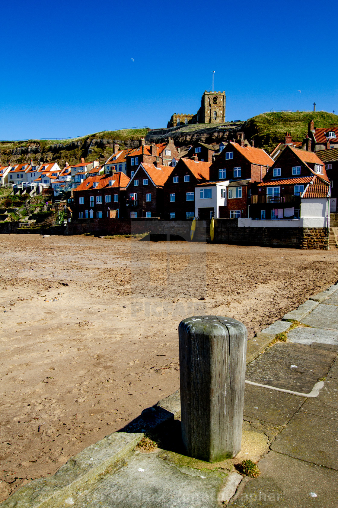 "Whitby,UK,Yorkshire,East coast, Mooring Post on Tate Hill Pier. Collier Hope Beach and St Mary's Church in the Background. Photographed April 2013." by Peter W. Clark - 'photographer' - £20.00 "Whitby,UK,Yorkshire,East coast, Mooring Post on Tate Hill Pier. Collier Hope Beach and St Mary's Church in the Background. Photographed April 2013." stock image