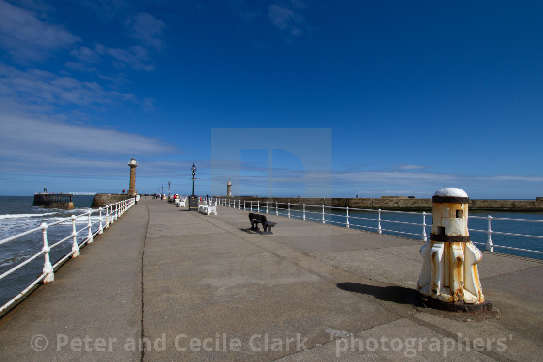 "Whitby,UK,Yorkshire,East coast, White Capstan on the Harbour Wall, Lighthouse in the Background." stock image