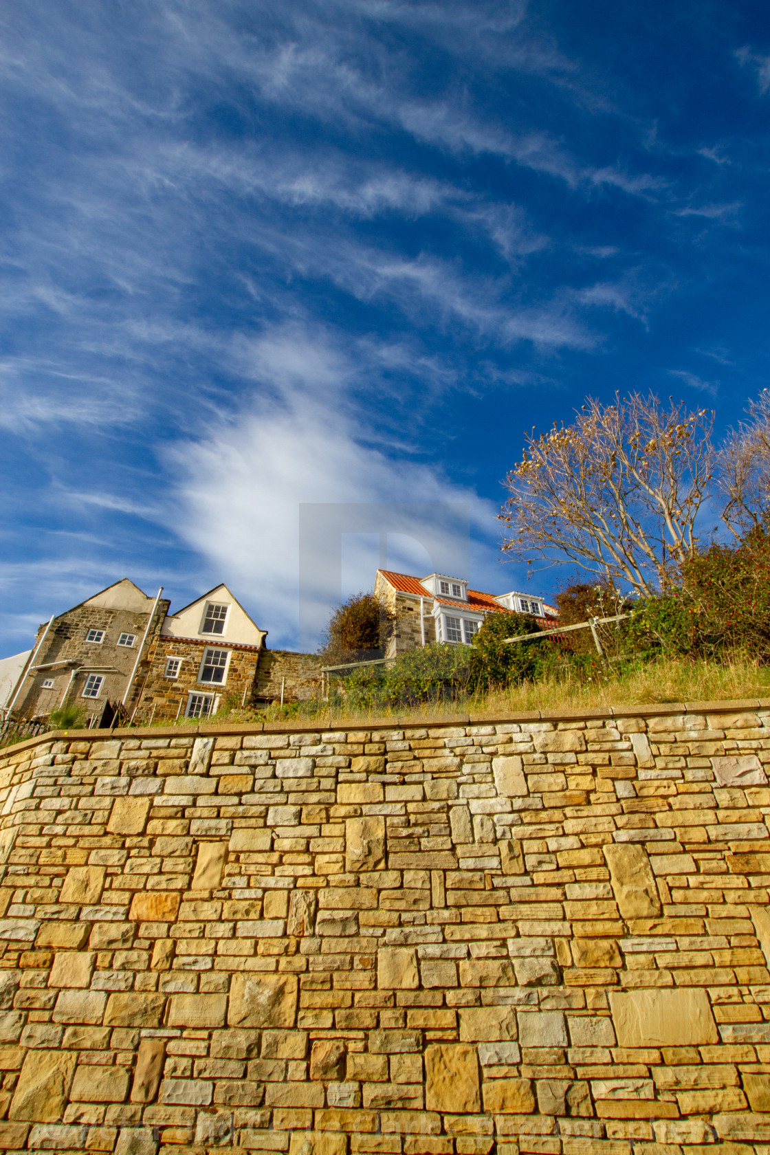 "Cottages above the sea wall, rear view. Robin Hoods Bay. External rear view on a sunny day." stock image