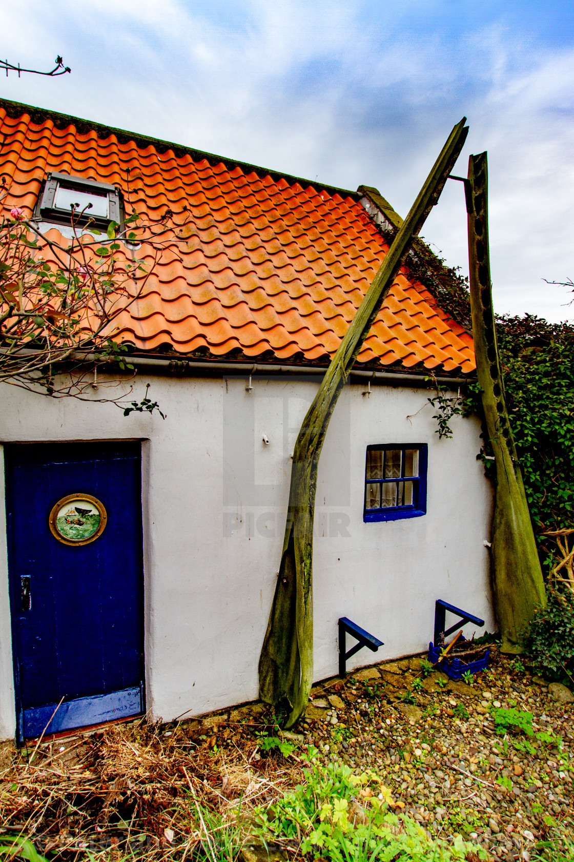 "Cottage in Robin Hoods Bay with Whalebone Arch in Garden." stock image