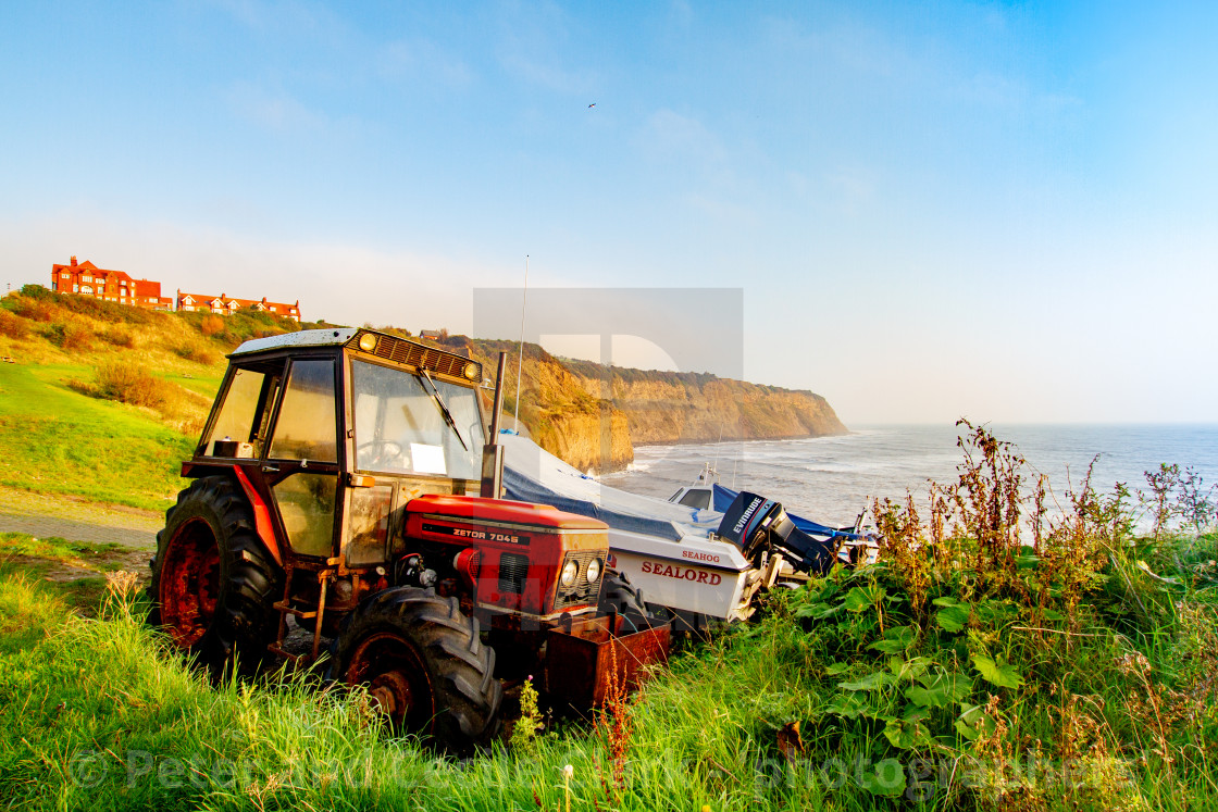 "Parked Zetor 7045 Red Tractor next to the Access to the Beach and Fishing Boats. Robin Hoods Bay, Yorkshire East Coast, England." stock image