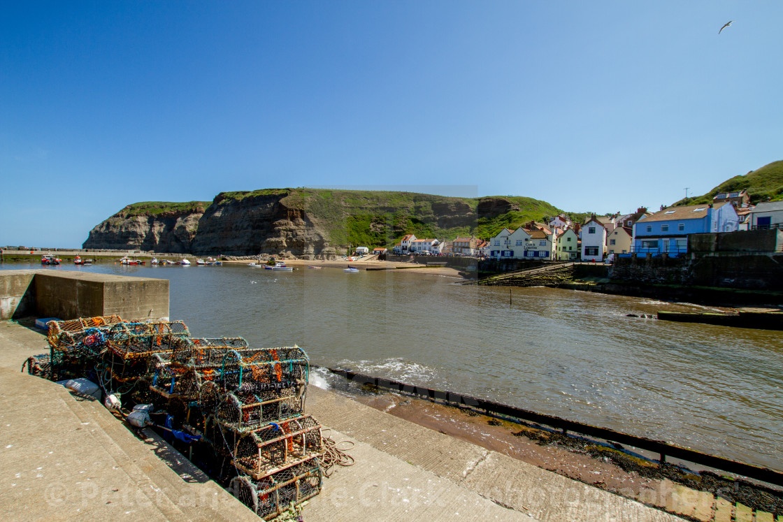 "Lobster Pots Stacked next to Slipway on North Side of Staithes Harbour, Yorkshire, England." stock image