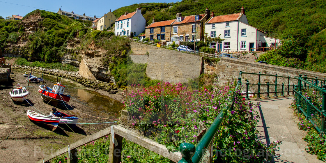 "Fishermens Cottages on Cowbar Bank, Moored Cobbles to the Foreground. Staithes, Yorkshire, UK" stock image