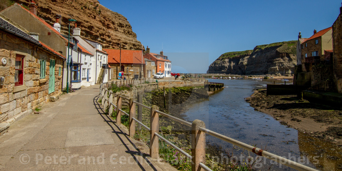 "View along Staithes Beck towards North Side Cottages, Cowbar Nab and the Harbour. Yorkshire, England." stock image