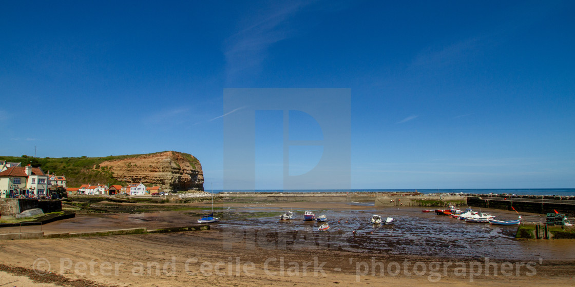 "Staithes Harbour at Low Tide, Cowbar Nab in the Background, Yorkshire, England." stock image