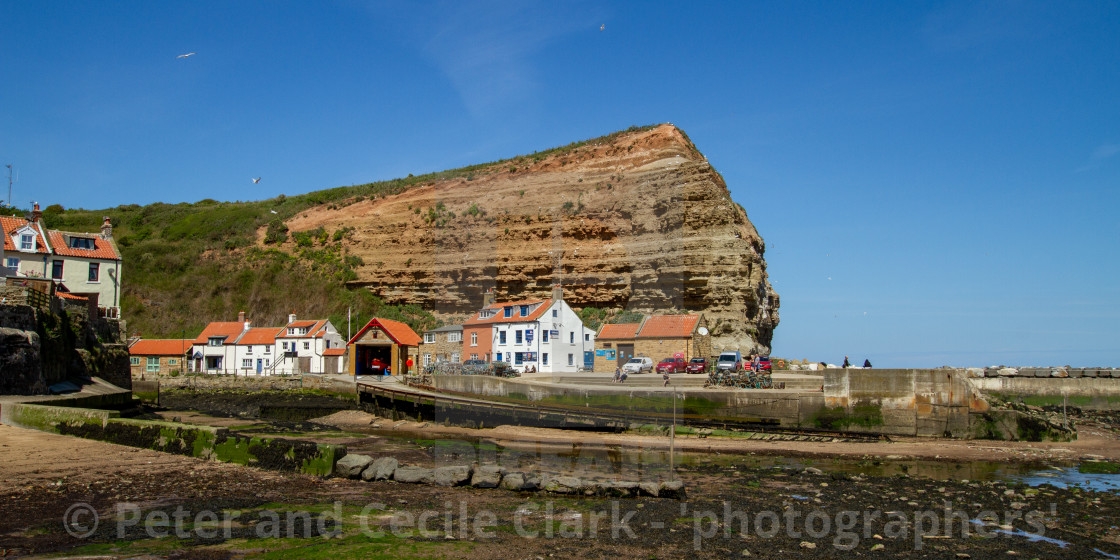 "Staithes Harbour at Low Tide, Cowbar Nab in the Background, Yorkshire, England." stock image