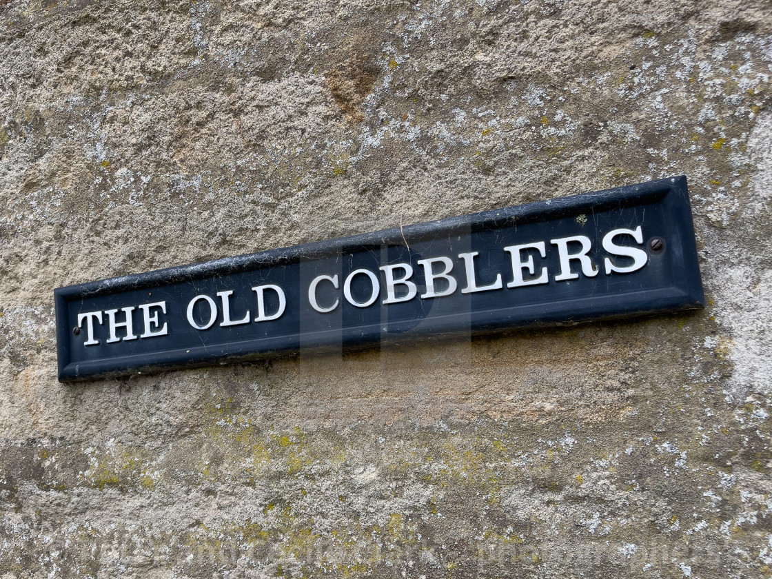 "The Old Cobblers, Sign on Stone Wall in Yorkshire Dales." stock image