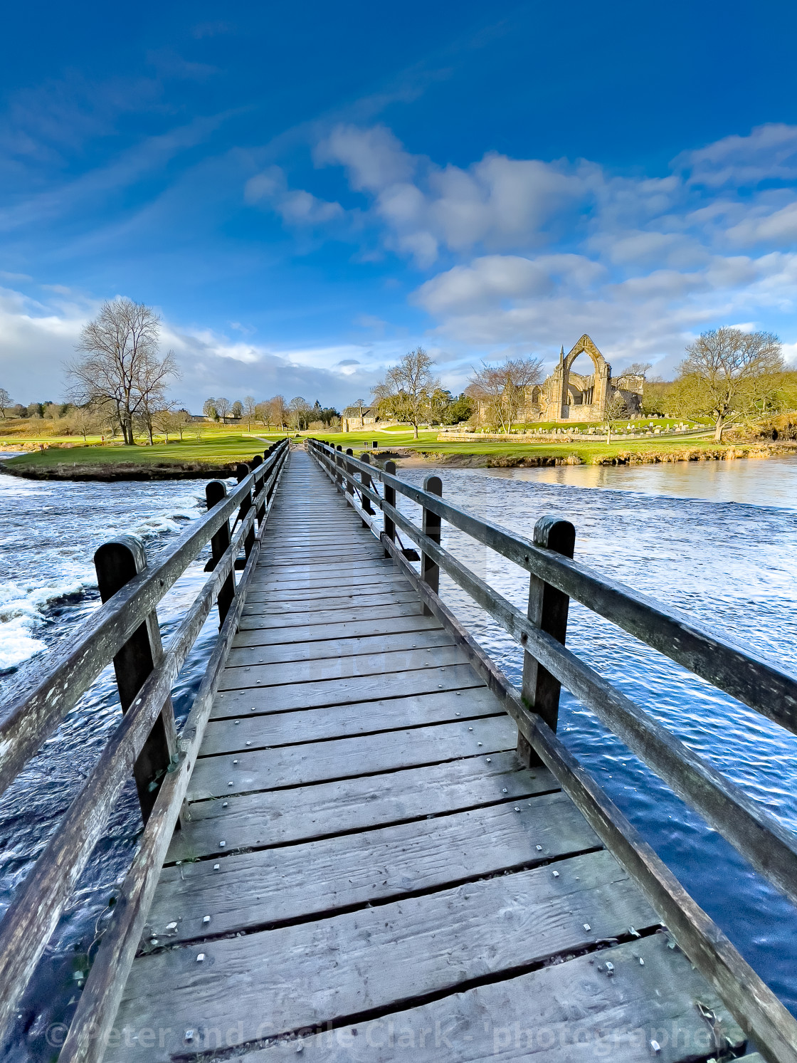 "River Wharfe Footbridge and Stepping Stones, Bolton Abbey, Priory Ruins in the Background." stock image