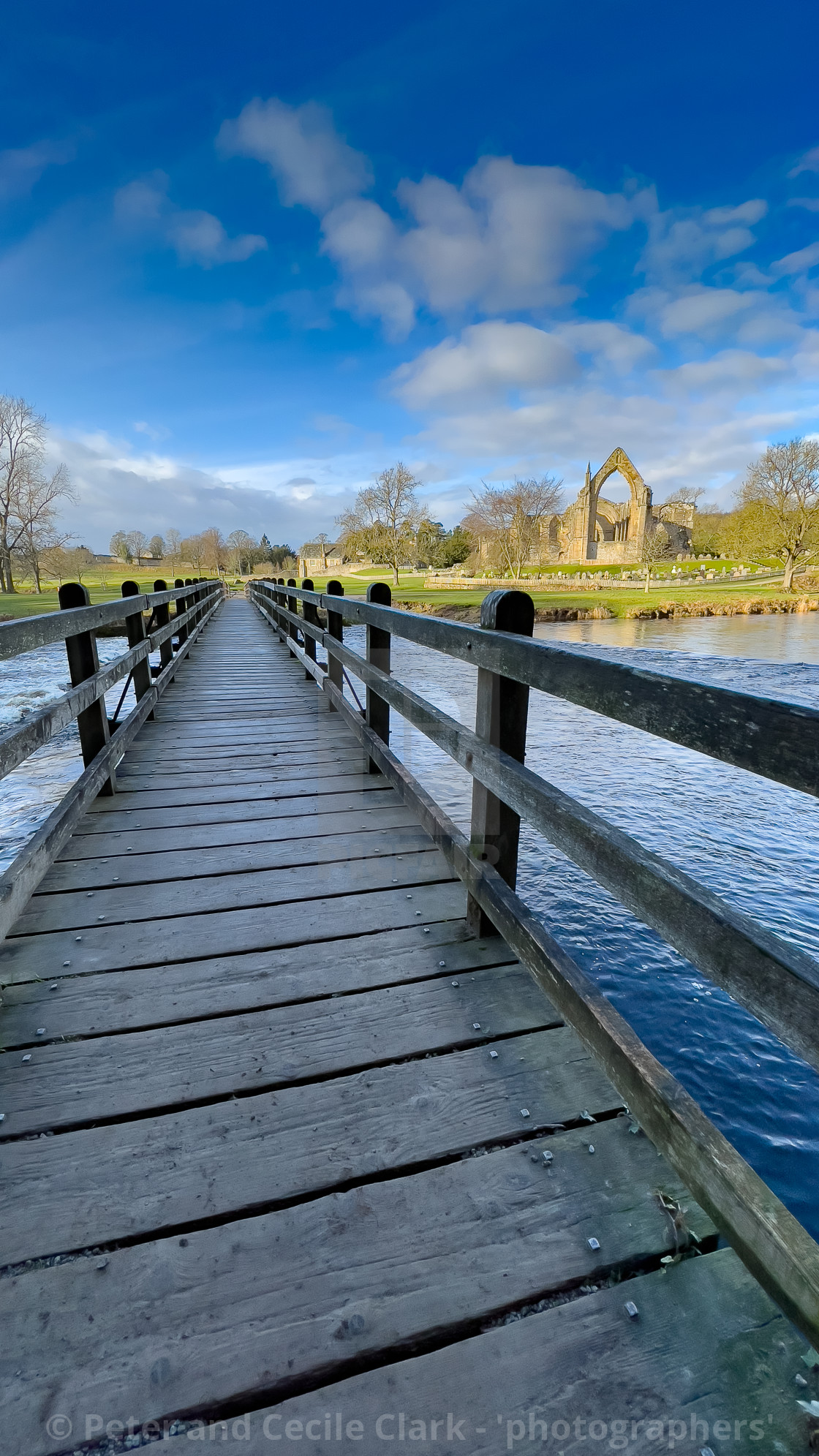 "River Wharfe Footbridge and Stepping Stones, Bolton Abbey, Priory Ruins in the Background." stock image