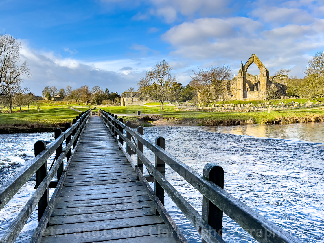 "River Wharfe Footbridge and Stepping Stones, Bolton Abbey, Priory Ruins in the Background." stock image