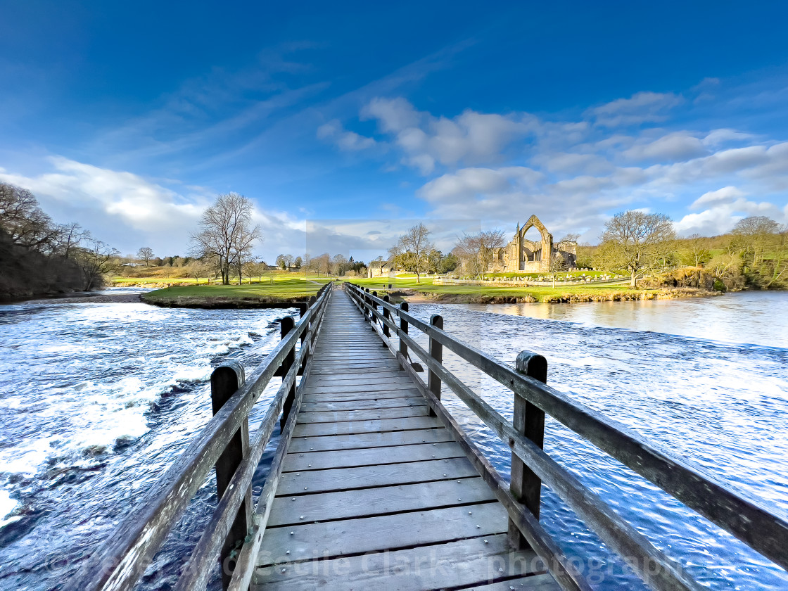 "River Wharfe Footbridge and Stepping Stones, Bolton Abbey, Priory Ruins in the Background." stock image