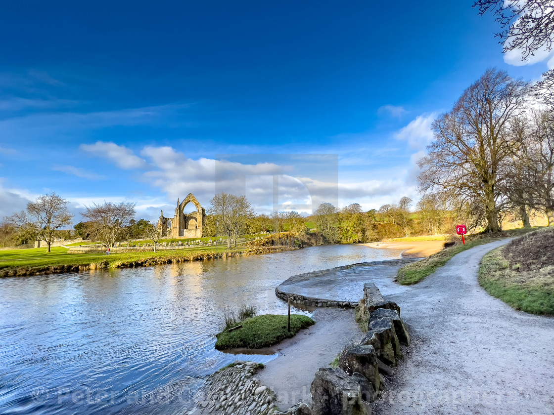 "River Wharfe and Stepping Stones, Bolton Abbey, Priory Ruins in the Background." stock image