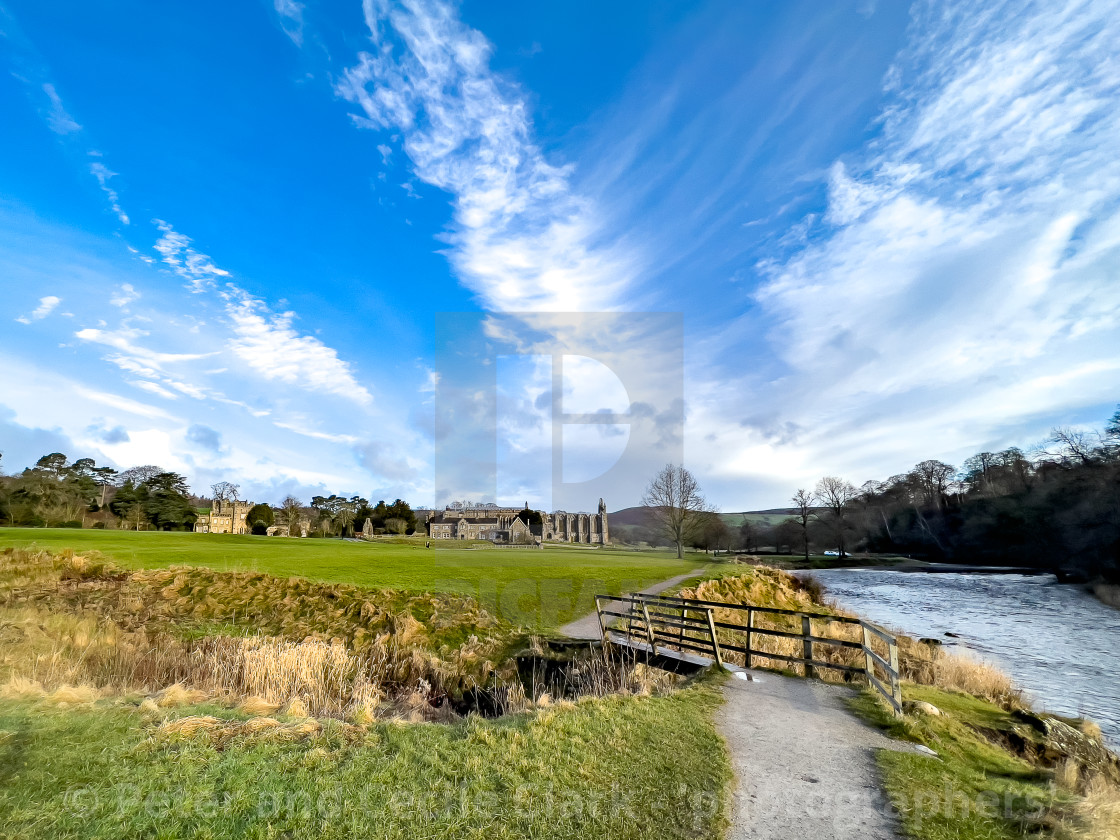 "River Wharfe, Footbridge, Bolton Abbey, Priory Ruins in the Background." stock image