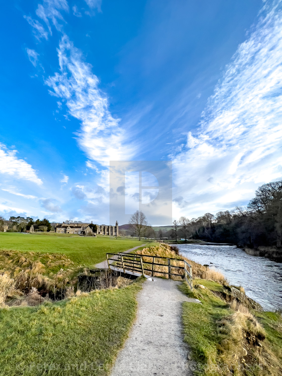 "River Wharfe, Footbridge, Bolton Abbey, Priory Ruins in the Background." stock image