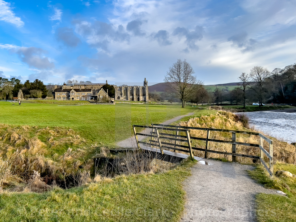 "River Wharfe, Footbridge, Bolton Abbey, Priory Ruins in the Background." stock image